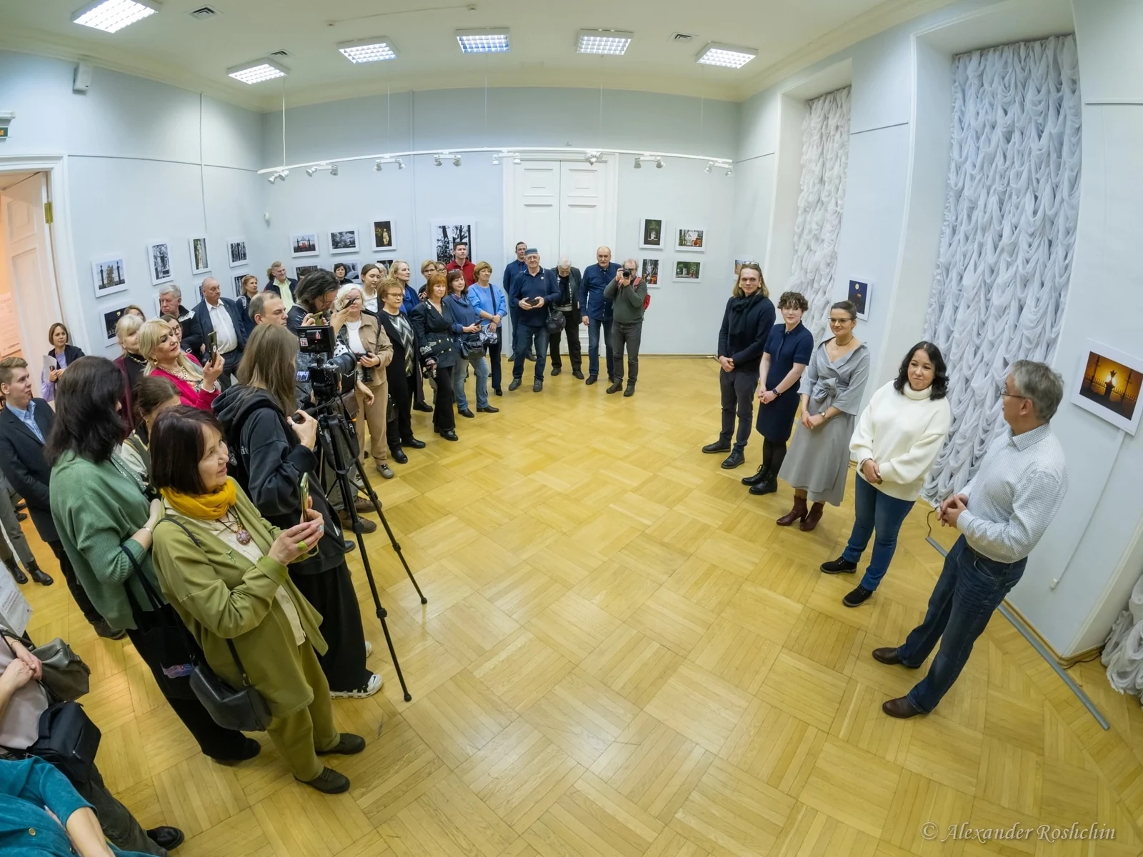 Открытие выставки «Летний. Времена года»: гости в зале с фотографиями на стенах